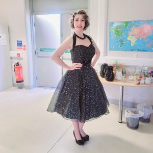 Jayne Darling is shown wearing black 1950s style dress and black shoes